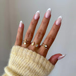 Bague double rang Ornella portée en accumulation (stacking) avec d'autres bagues fines et pierres blanches.