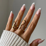 Bague Paola style moderne et artistique portée sur la main, design filaire doré original.