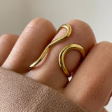 Gros plan bague ouverte forme organique et fluide ajustable au doigt.