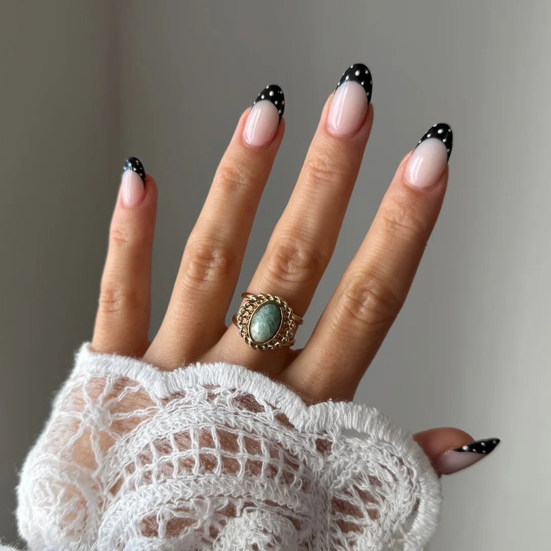 Bague Pauline style vintage bohème avec pierre turquoise portée sur une main avec manche en dentelle.