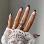 Bague Pauline style vintage bohème avec pierre turquoise portée sur une main avec manche en dentelle.