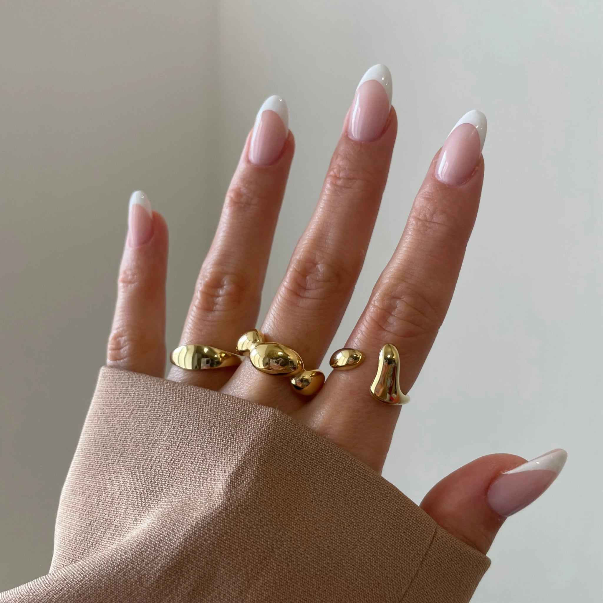 Bague Prisca portée en accumulation avec d'autres bijoux dorés, l'essentiel pour un stacking réussi.