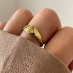 Gros plan bague Prisca forme ovale bombée et lisse portée au doigt, style basique intemporel.