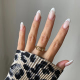 Bague nœud torsadé Roberta portée en accumulation (stacking) avec d'autres bagues fines dorées.