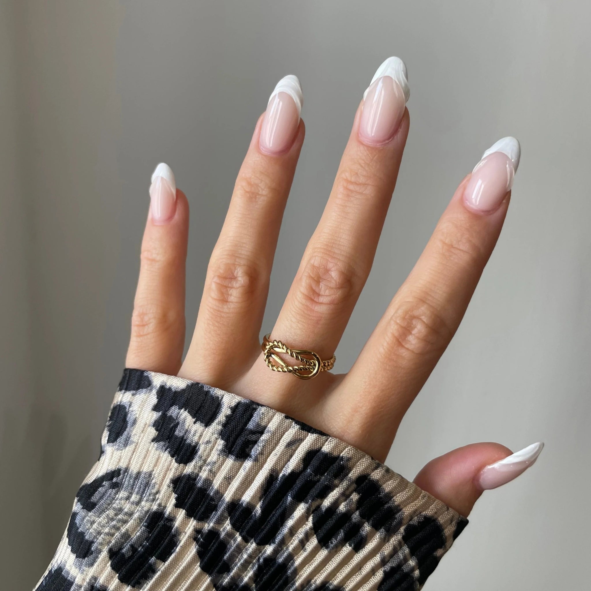 Bague nœud torsadé Roberta portée en accumulation (stacking) avec d'autres bagues fines dorées.