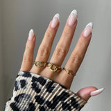 Bague nœud torsadé Roberta portée en accumulation (stacking) avec d'autres bagues fines dorées.