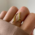 Gros plan bague Samanta au design organique et fluide portée au doigt, style moderne et graphique.