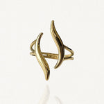 Bague ouverte ajustable en acier inoxydable doré avec motif double flamme ou vagues courbes sur fond blanc.