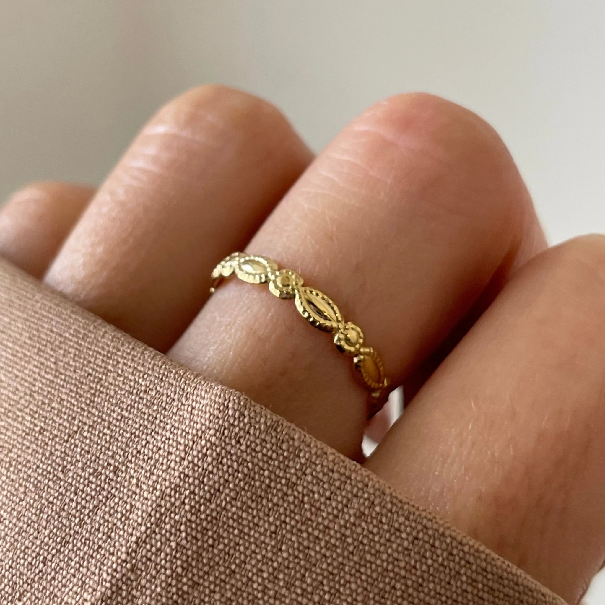 Gros plan bague fine Savanna à motifs texturés portée au doigt, bijou discret.
