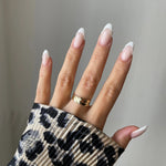 Bague large Svetlana portée en accumulation (stacking) avec d'autres bagues géométriques dorées.