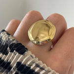 Gros plan bague Tatiana forme pastille XXL ou médaille bombée portée au doigt, style statement affirmé.