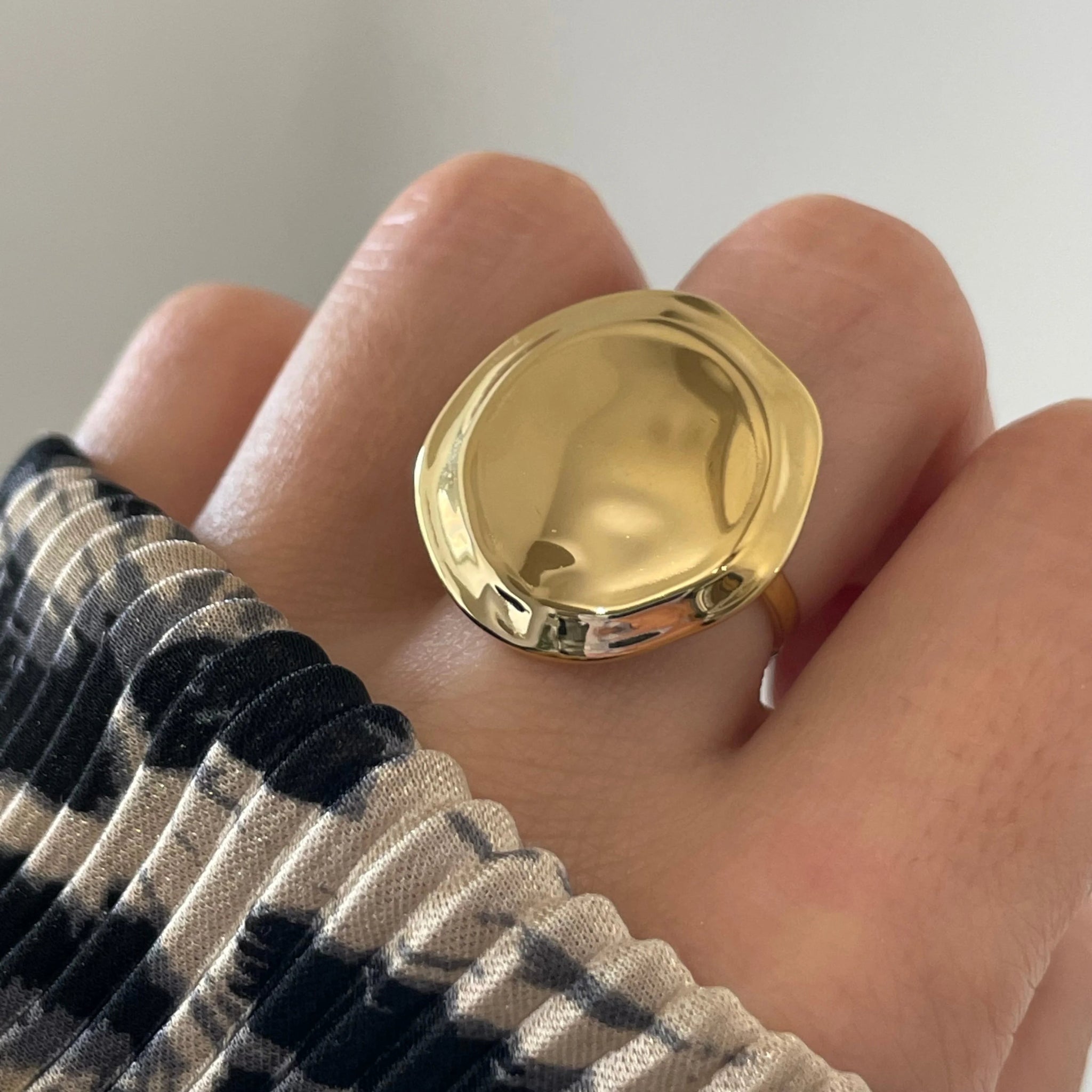Gros plan bague Tatiana forme pastille XXL ou médaille bombée portée au doigt, style statement affirmé.
