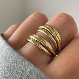 Gros plan bague Teresa à lignes multiples enroulées portée au doigt, style moderne et volumineux.