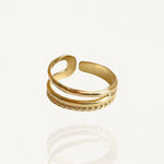 Bague ouverte effet double rang en acier inoxydable doré : un anneau lisse et un anneau texturé perlé sur fond blanc.