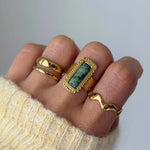 Bague Veronika portée en accumulation (stacking) avec la bague vague Andrea et d'autres anneaux dorés.