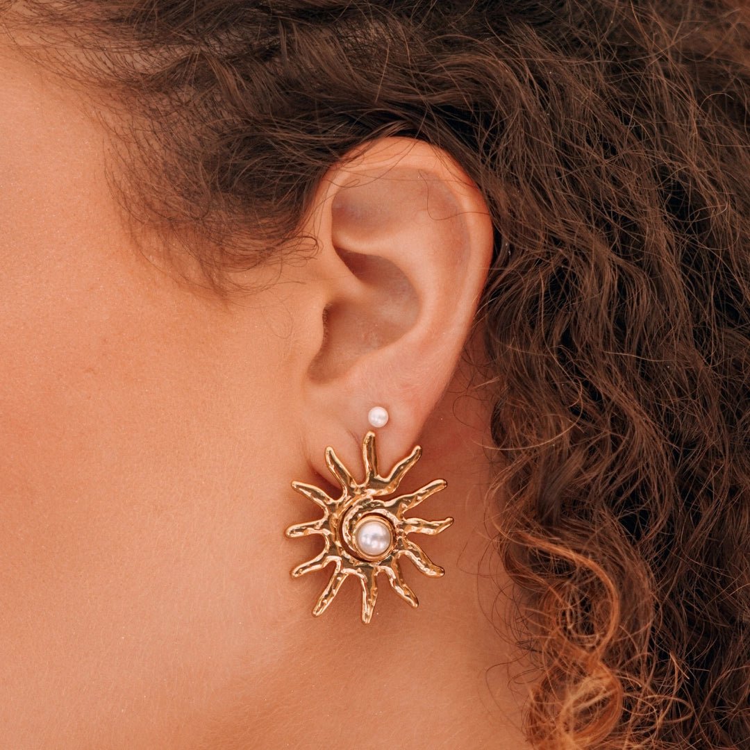 Boucles d'oreilles en acier inoxydable doré: un soleil texturé avec perle centrale et un stud perle. Portées.
