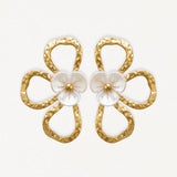 Boucles d'oreilles en acier inoxydable doré martelé, design fleur évidée avec fleur centrale nacrée et pistil doré.