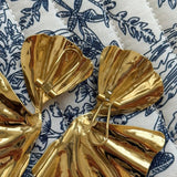 Gros plan sur la texture froissée et le relief des boucles d'oreilles feuilles Amaya, style nature et végétal.