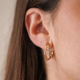 Boucles d'oreilles graphiques Celine forme losange ou hexagone portées au lobe, en accumulation avec le ear climber Ariane.