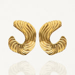 Gros plan boucles d'oreilles créoles ouvertes larges avec relief côtelé ou plissé sur fond blanc.