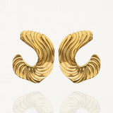 Gros plan boucles d'oreilles créoles ouvertes larges avec relief côtelé ou plissé sur fond blanc.