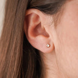 Boucle d'oreille puce minimaliste Iris portée seule au lobe, bijou discret et intemporel.