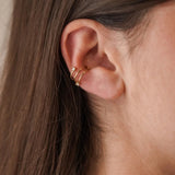 Gros plan sur le faux piercing d'oreille Jennifer à trois anneaux dorés, ajustable sans perçage.