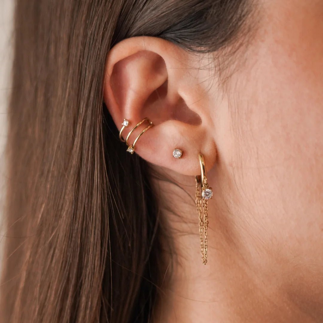 Ear cuff Jennifer porté au cartilage en accumulation avec d'autres boucles d'oreilles pendantes.