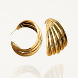 Paires de créoles larges effet triple rangs en acier inoxydable doré, finition brillante sur fond blanc.