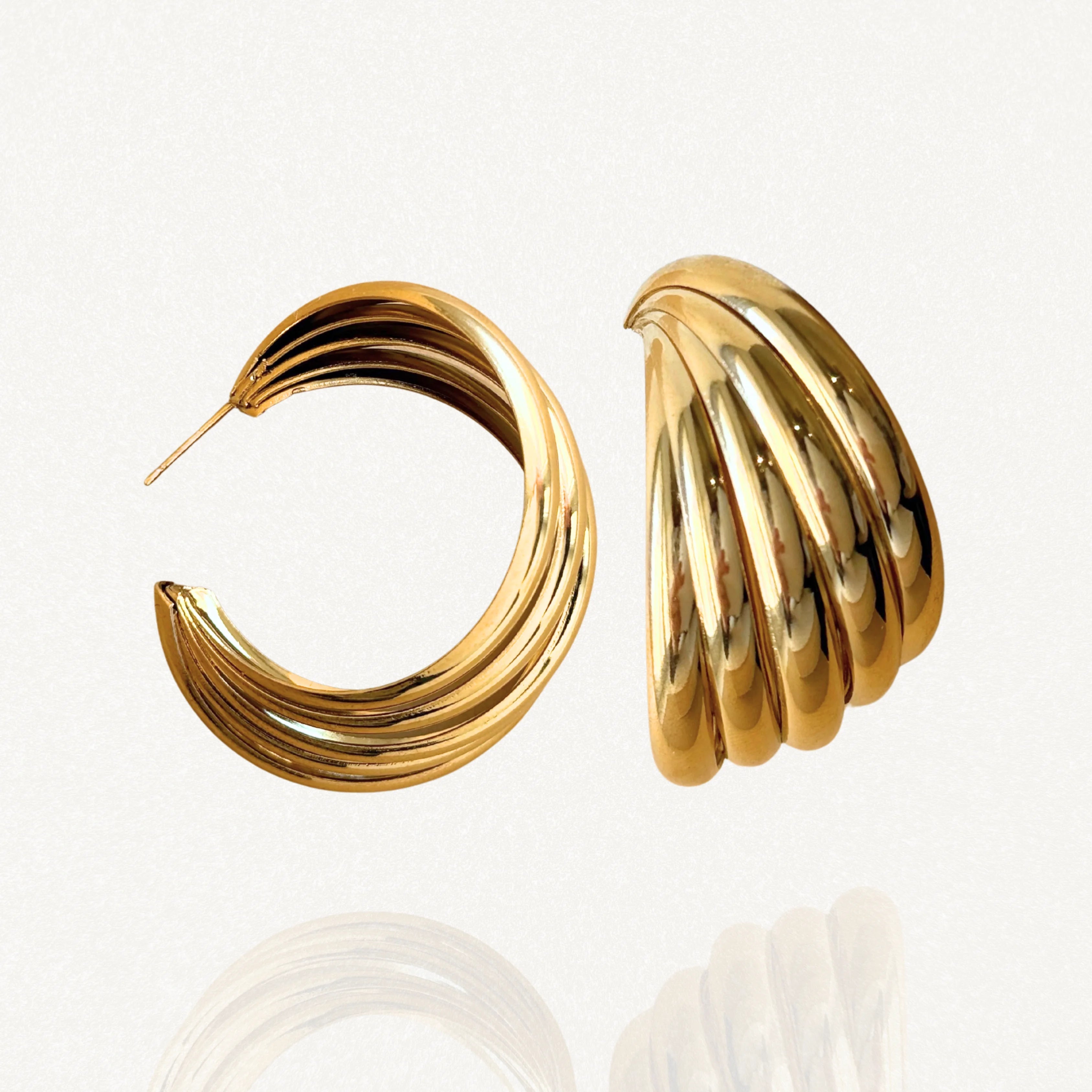 Paires de créoles larges effet triple rangs en acier inoxydable doré, finition brillante sur fond blanc.