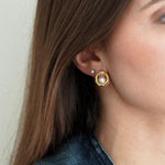 Lobe d'oreille de femme avec boucle stud dorée forme organique & perle, et petite puce d'oreille perle blanche.