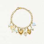 Bracelet chaîne en acier inoxydable doré orné de multiples breloques : cœur sacré ex-voto, cœur blanc, perle nacrée et perle fleur.