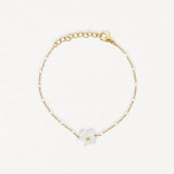 Bracelet en acier inoxydable doré avec chaîne perlée blanche et fleur de nacre.