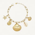 Vue d'ensemble bracelet doré à charms marins : étoile de mer, coquille Saint-Jacques et cauri naturel sur fond blanc.