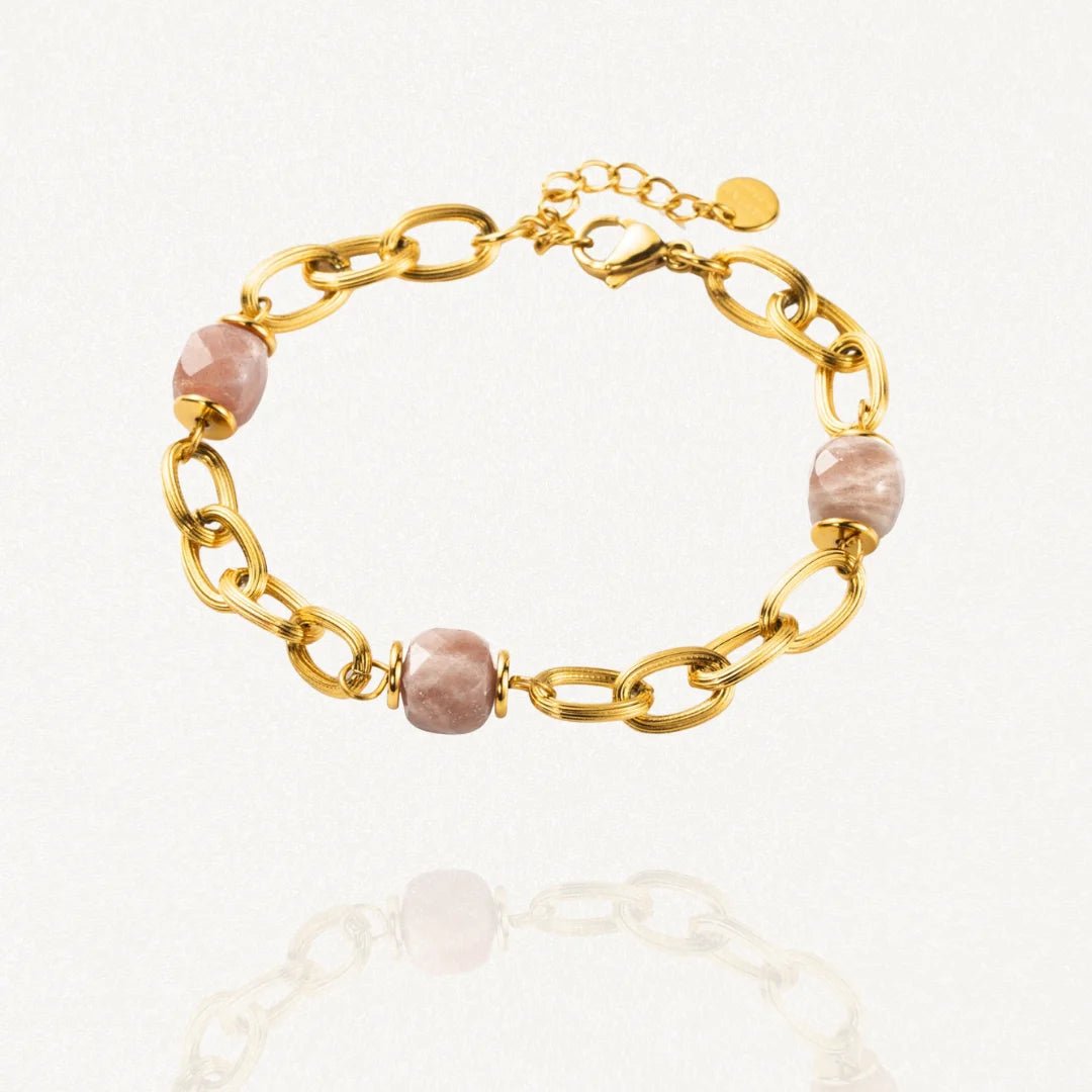 Bracelet grosse maille acier doré avec perles Roses sur fond blanc.