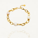 Bracelet grosse maille acier doré avec perles Blanches sur fond blanc.