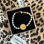 Bracelet perles Heloise style antique présenté dans son écrin cadeau Maison de l'Amour sur fond léopard.