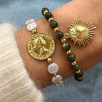 Bracelet perles et pièce Henriette porté en accumulation (stacking) avec un bracelet perles vertes à breloque cœur.