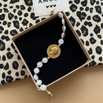 Bracelet perles blanches et médaille Henriette présenté dans son écrin cadeau Maison de l'Amour.