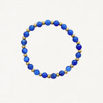 Bracelet fin perles Bleues et billes dorées sur fond blanc.