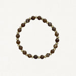 Bracelet fin perles Marrons et billes dorées sur fond blanc.