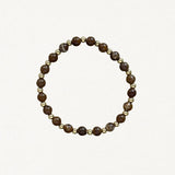 Bracelet fin perles Marrons et billes dorées sur fond blanc.