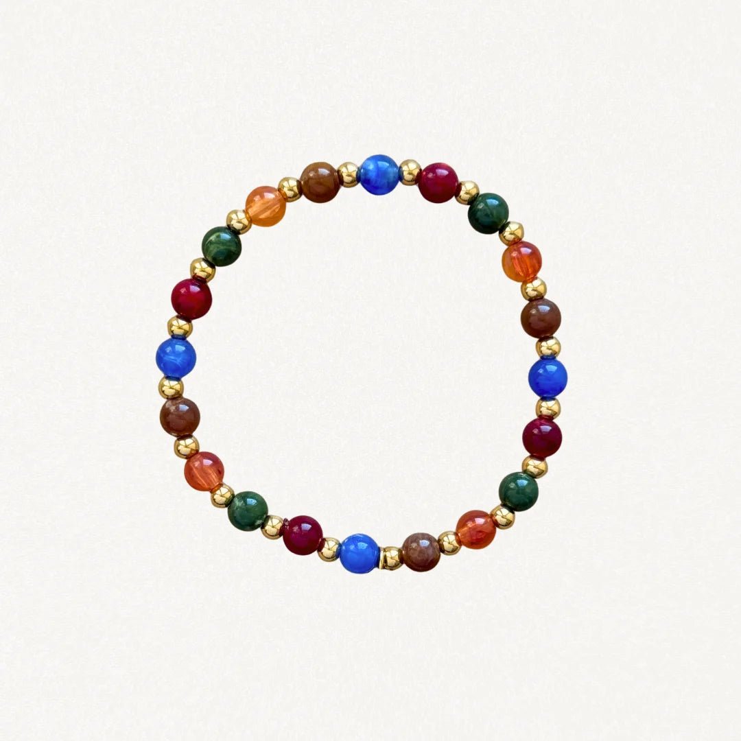 Bracelet fin perles Multicolores et billes dorées sur fond blanc.