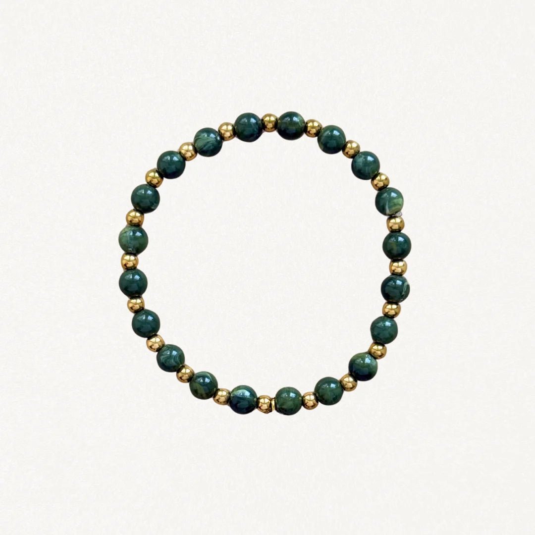 Bracelet fin perles Vertes et billes dorées sur fond blanc.