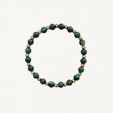 Bracelet fin perles Vertes et billes dorées sur fond blanc.