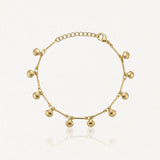 Bracelet en acier inoxydable doré orné de petits pendentifs coquillages et de barres fines. Chaîne ajustable.