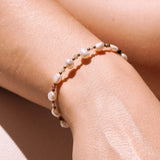 Bracelet en acier inoxydable avec perles de culture baroques, perles dorées et pierres naturelles colorées au poignet.