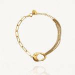 Vue d'ensemble bracelet asymétrique doré : moitié chaîne multi-rangs, moitié chaîne maillons, avec connecteur forme abstraite.