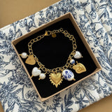 Bracelet à charms cœurs et porcelaine bleue présenté dans son écrin cadeau Maison de l'Amour.