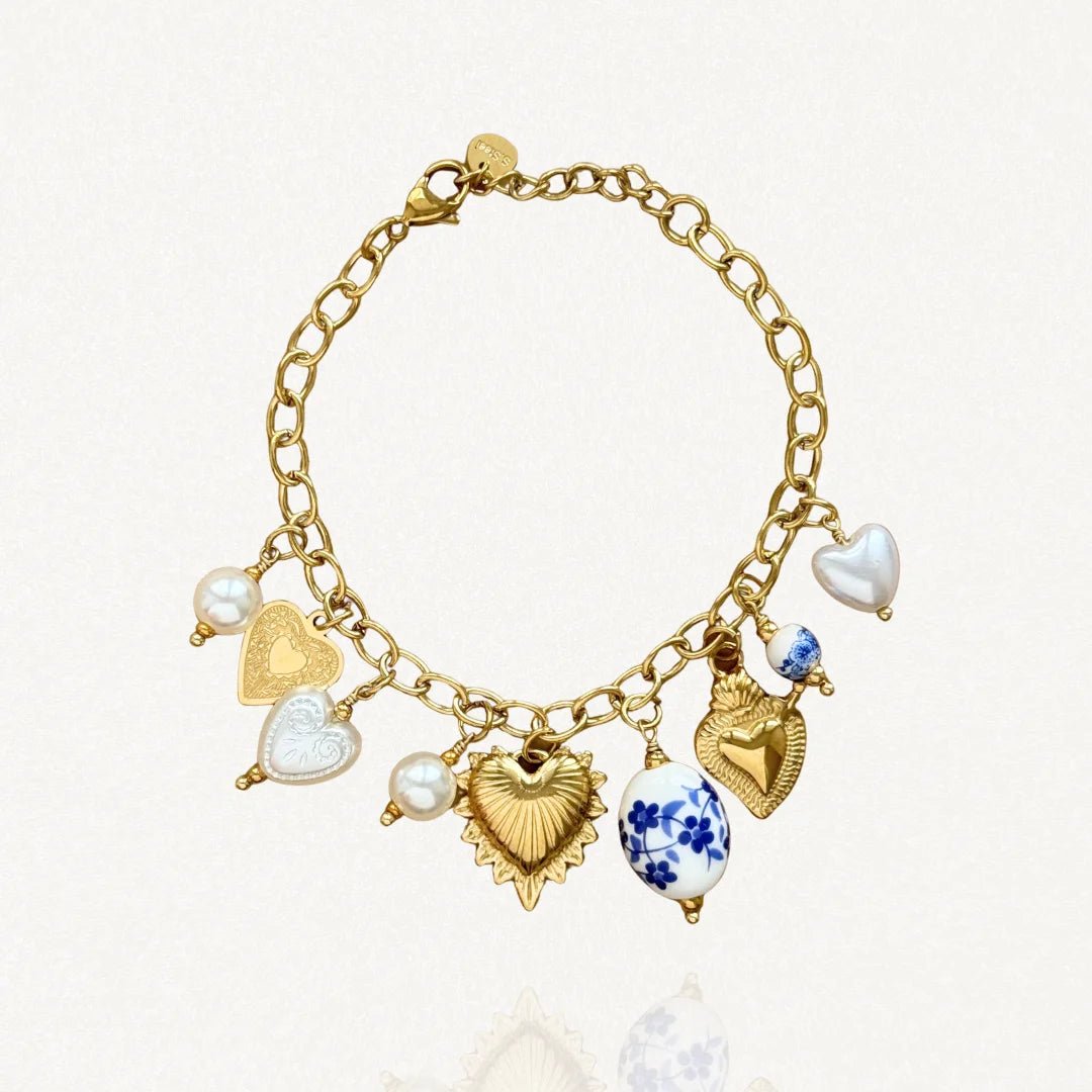 Vue d'ensemble bracelet chaîne acier inoxydable doré avec multiples pendentifs cœurs et perles bleues.